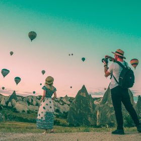 Man taking photo of hot air balloons